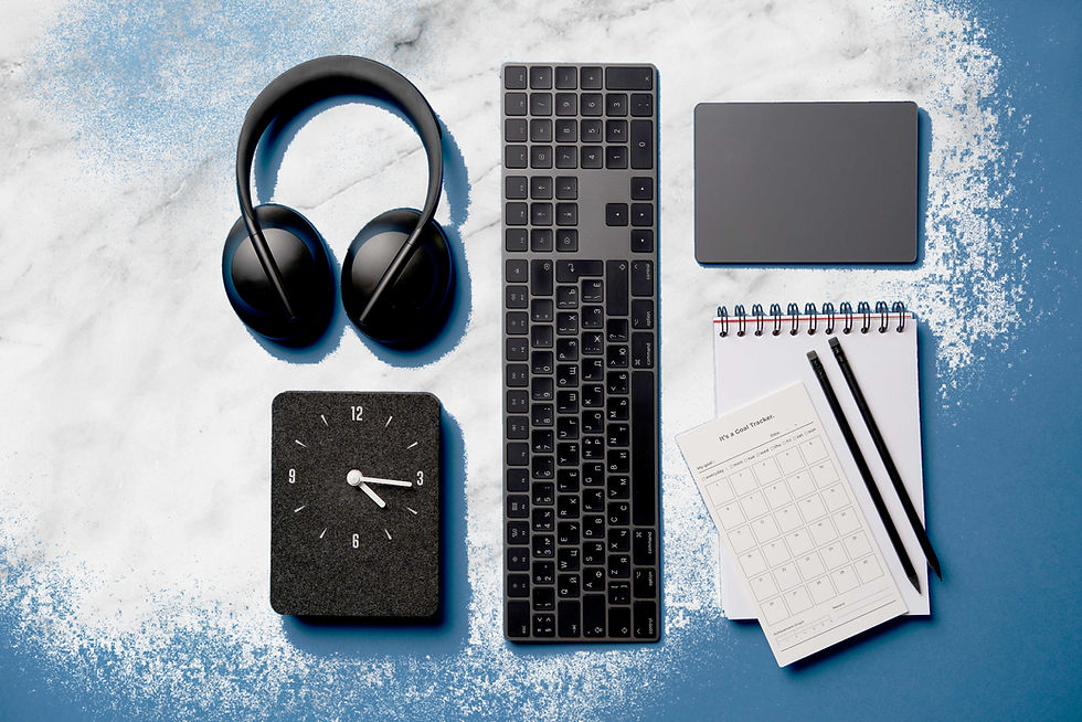 a collection of black headset, keyboard, clock, mousepad, 2 pencils and an open notepad