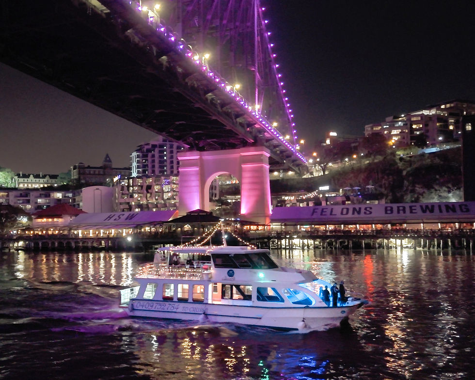 Party cruise boat under Brisbane’s Story Bridge, lit with purple.