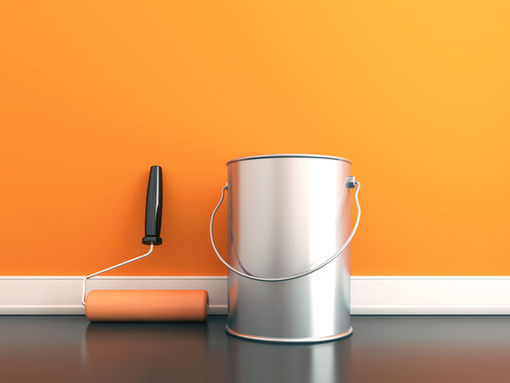 Blank can of paint in front of an orange wall.