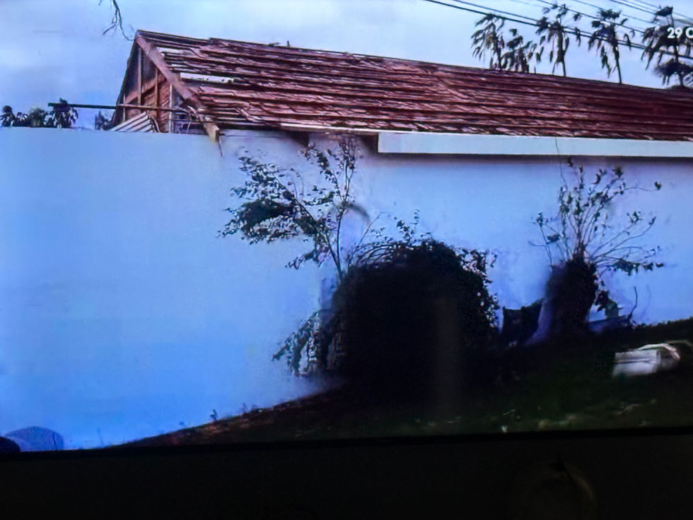 Eye-level view of a small house damaged by hurricane debris