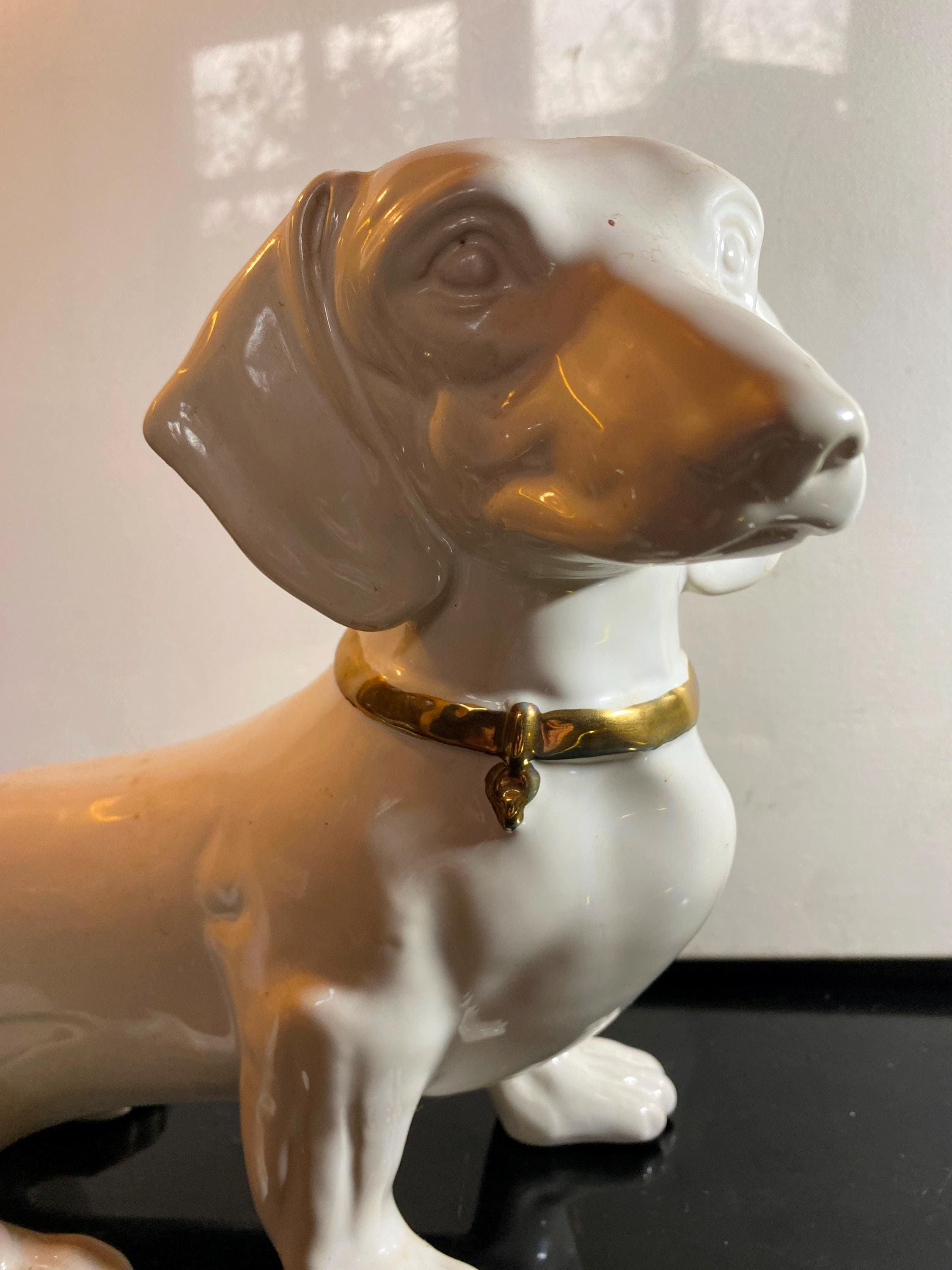 Weißer Porzellan-Dackelwelpe mit goldenem Halsband