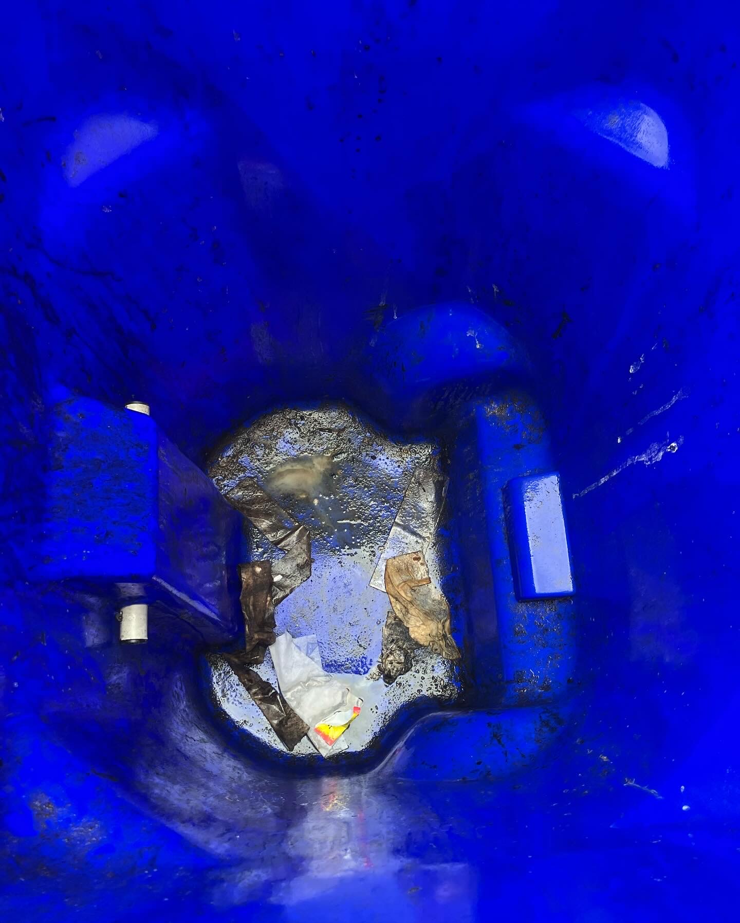 A dry and empty garbage bin interior.
