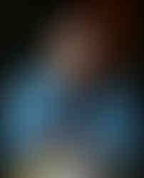 Zach wears a plaid shirt and looks into the camera.