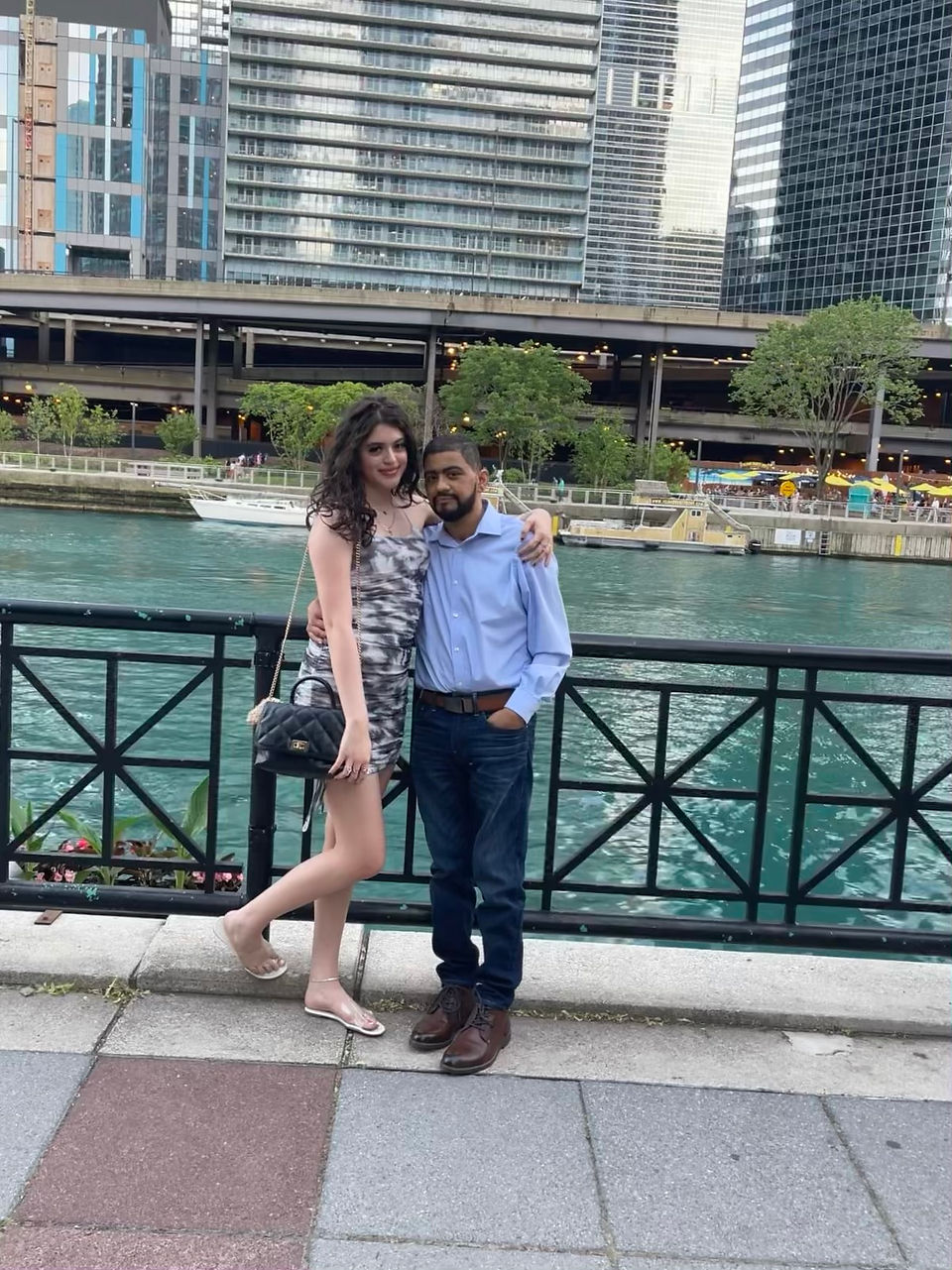 Leo and his daughter Gaby, dressed formally in front of a body of water. 
