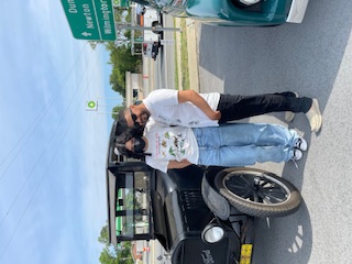 Leo and his daughter Camila, standing next to a vintage car at a car show.