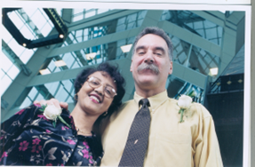 Harold and Gennet smiling after meeting for the first time, wearing a rose corsage in celebration on their shirts.