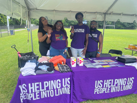 Four representatives from Us Helping Us People Into Living at Infinite Legacy's District Heights, MD, Block Party. 