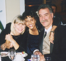 Harold and his wife, Susan, are with Gennet at a formal dinner event.