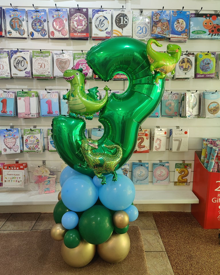 Green number 3 balloon display with dinosaur decorations
