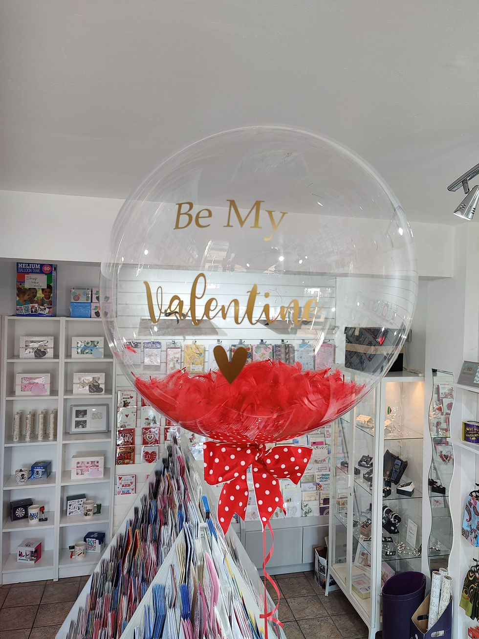 Large clear balloon; "Be My Valentine" message; red feathers, polka dot bow