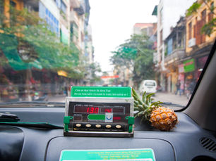 The inside of a Vietnam taxi, with a pineapple on the dashboard