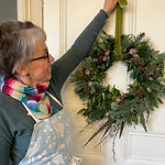 workshop participant hanging a handmade christmas wreath