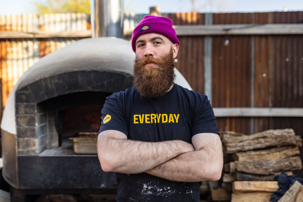 a man with a beard wears a black shirt that says everyday