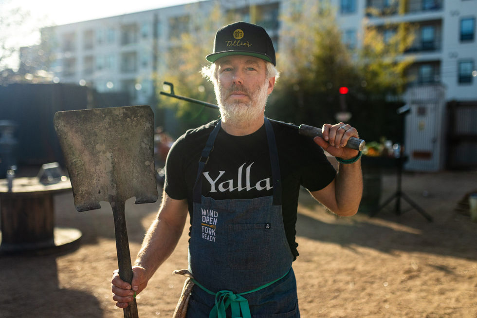 a man wearing an apron that says yalla on it