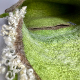 Green inside and pocket of a felted bag with raw wool lid