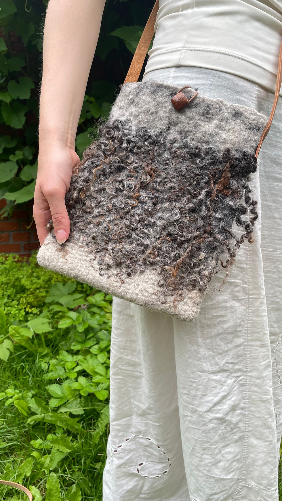 Miniaturebillede: Mørke krøller på råuldstaske