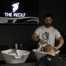 Cliente recibiendo lavado capilar en The Wolf Salon.