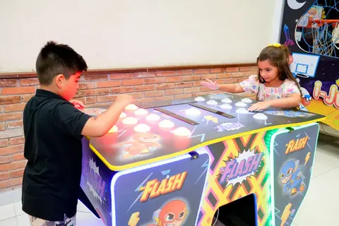Crianças se divertem com jogos de mesa eletrônicos, no espaço para festa infantil do Buffet Aquarella Park, localizado na zona sul de São Paulo