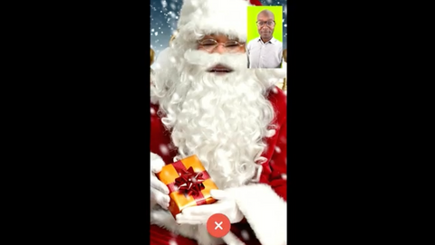 man with glasses in front of green screen with Christmas decorations