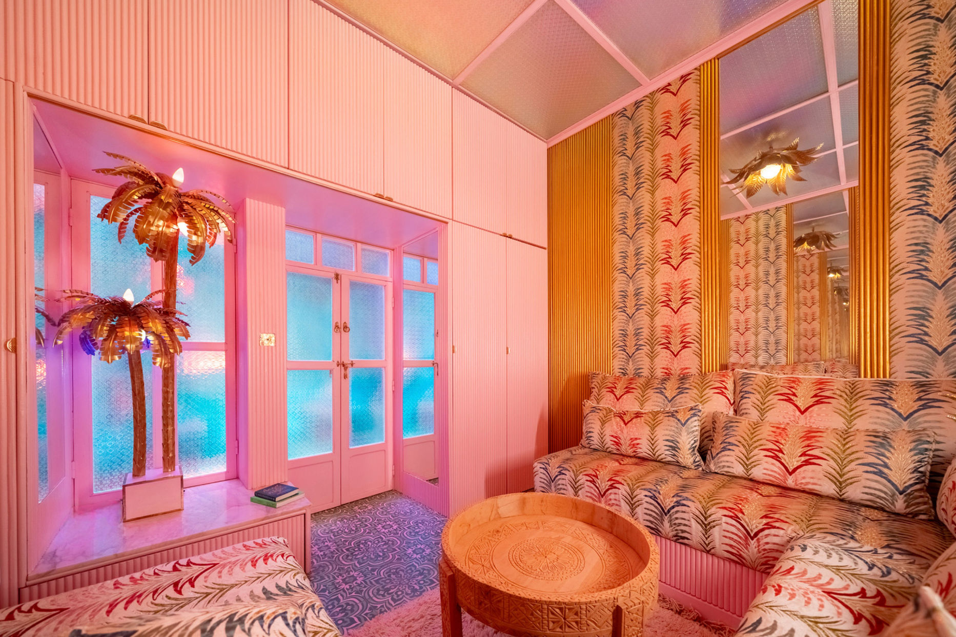 Embroidered seating and pink cabinetry under colour-shifting glass ceiling at Starseed House Marrakech