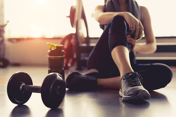 Woman exercise workout in gym fitness breaking relax holding apple fruit after training sp