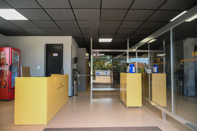 Recepção da Academia Madalozzo Fitness com totem para exposição de produtos.