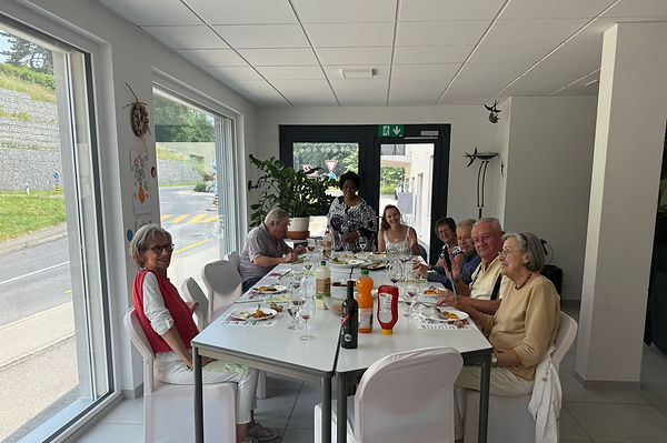 Des seniors avec des jeunes en mangeant ensemble, autour une table