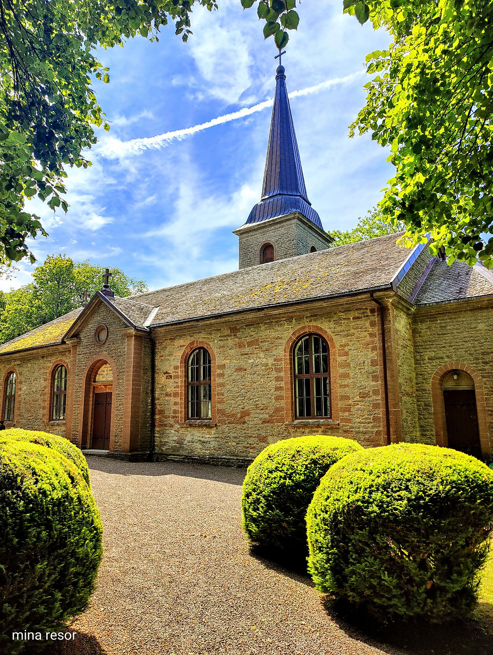 en medeltida kyrka bland träden i Kinnekulle.