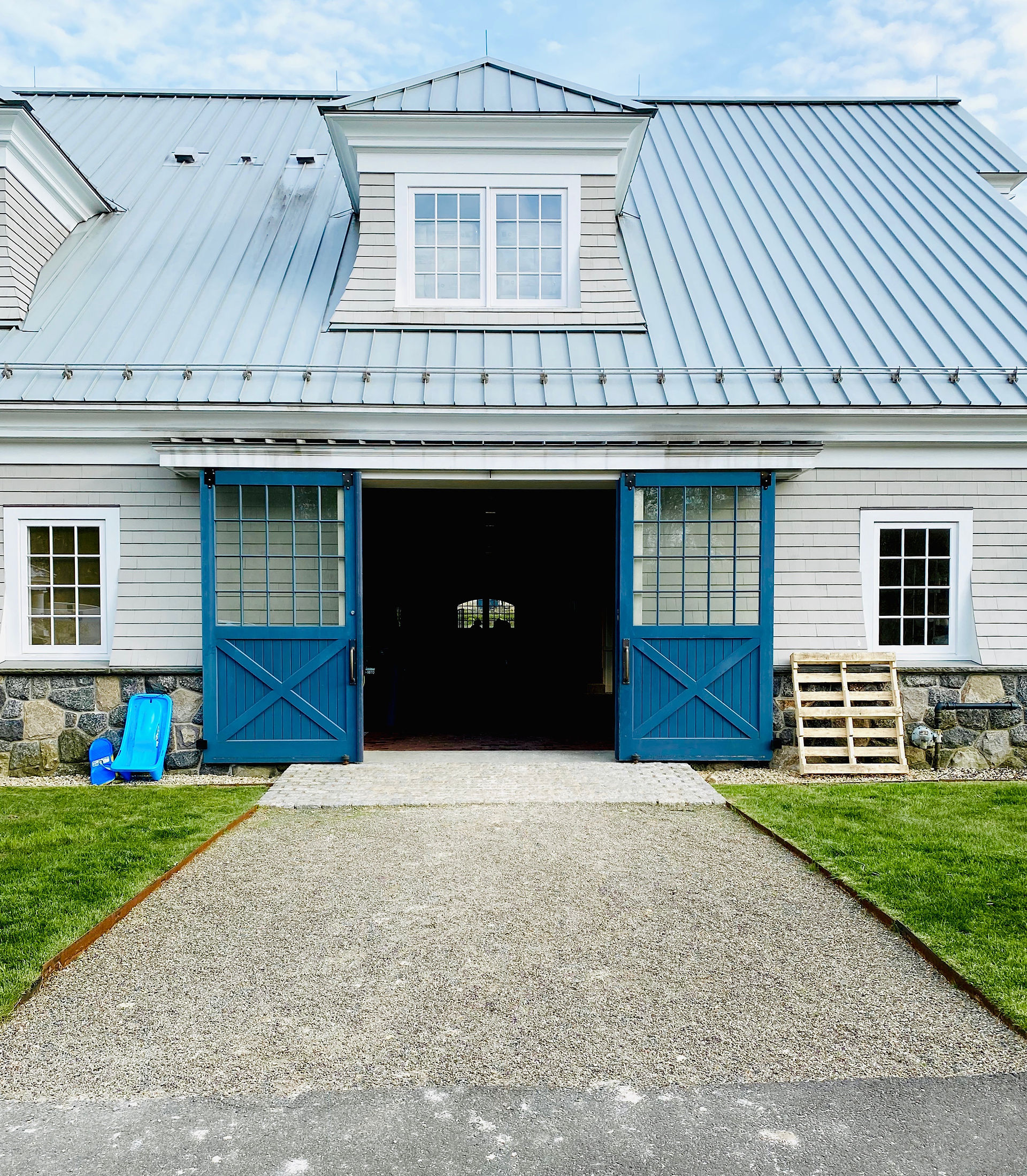 Blue barn doors with stone pathway