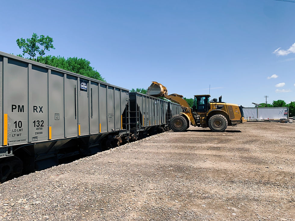 loader loading train at landscape supply yard