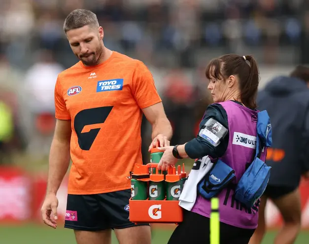 Football player receiving hydration support during a sporting event.