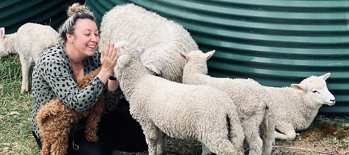 Nicole from No Eye Deer Farm surrounded by her sheep