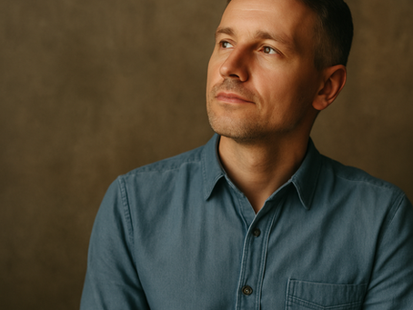 Thoughtful man in a denim shirt gazing sideways, symbolizing reflection and personal growth—representing the power of a growth mindset.