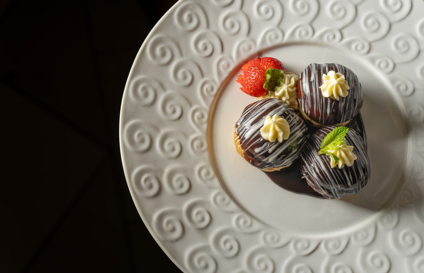 Le Bistro Musicale profiteroles dessert with chocolate sauce and strawberry from Carnival Cruise Line’s new French-inspired restaurant