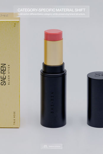 Gold blush stick carton next to matching black and gold cylindrical blush product.