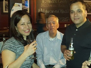A woman and two men drinking in a publ.