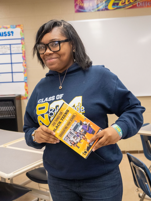 Student holding 50 Things for Black Teens to Experience Before Graduating High School
