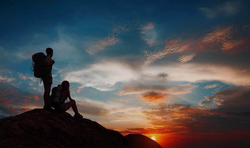 Backpacker hikers on mountian at sunset