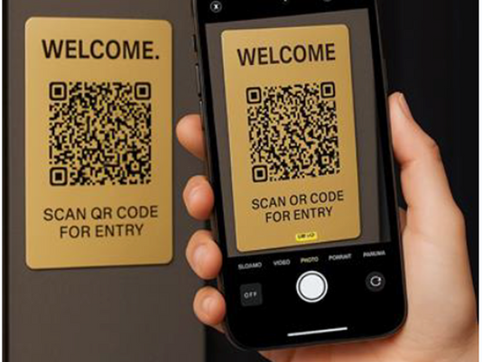 Smartphone scanning a QR code on a building entrance panel for secure access