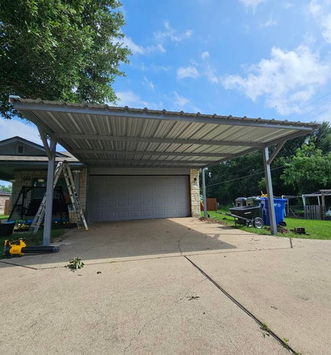 Open galvalume metal carport in Waco, Texas, with a modern steel roof supported by durable steel framing, located next to a concrete driveway.