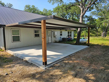 A brown metal covered patio in Waco, Texas, featuring a modern steel roof and durable steel framing, ideal for outdoor gatherings and protection from the elements.