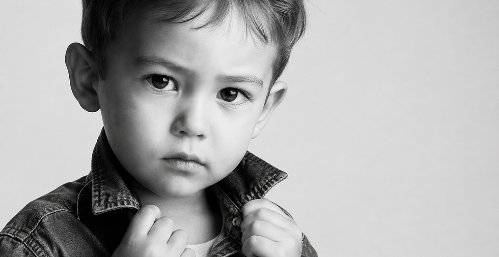 Zwart-wit kinderportret van jonge jongen in denimjasje