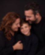 Gezinsfotografie van een lachend gezin met kind in de studio.