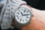 white FARER watch on wrist with gray sweater