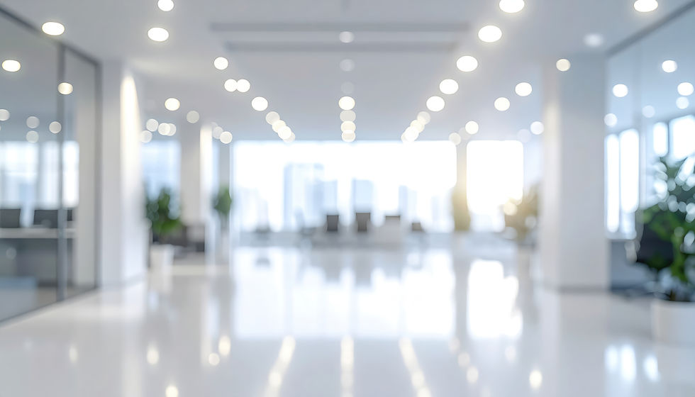 A bright, modern, and spacious office interior with reflective white floors, overhead ligh