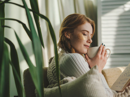 pretty woman sitting on couch covered with a blanket. Cosy home scene