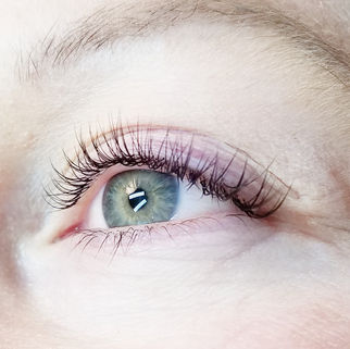 Close up of woman's open eye to show full, black colored, eyelash extensions.