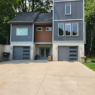 Modern home exterior with two grey garage doors.