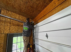 Technician performing garage door repair and service.