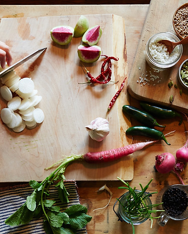 Fresh vegetables being chopped on a cutting board during a cooking lesson